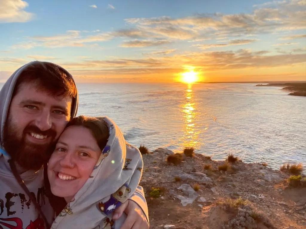 Tim and Ash with water and a sunset behind them